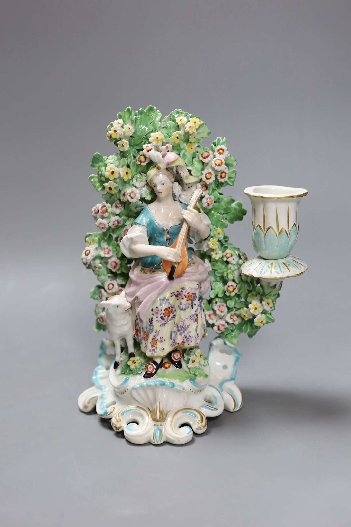 A Derby bocage candlestick, c.1770, modelled as a lady playing a lute, 19cms high